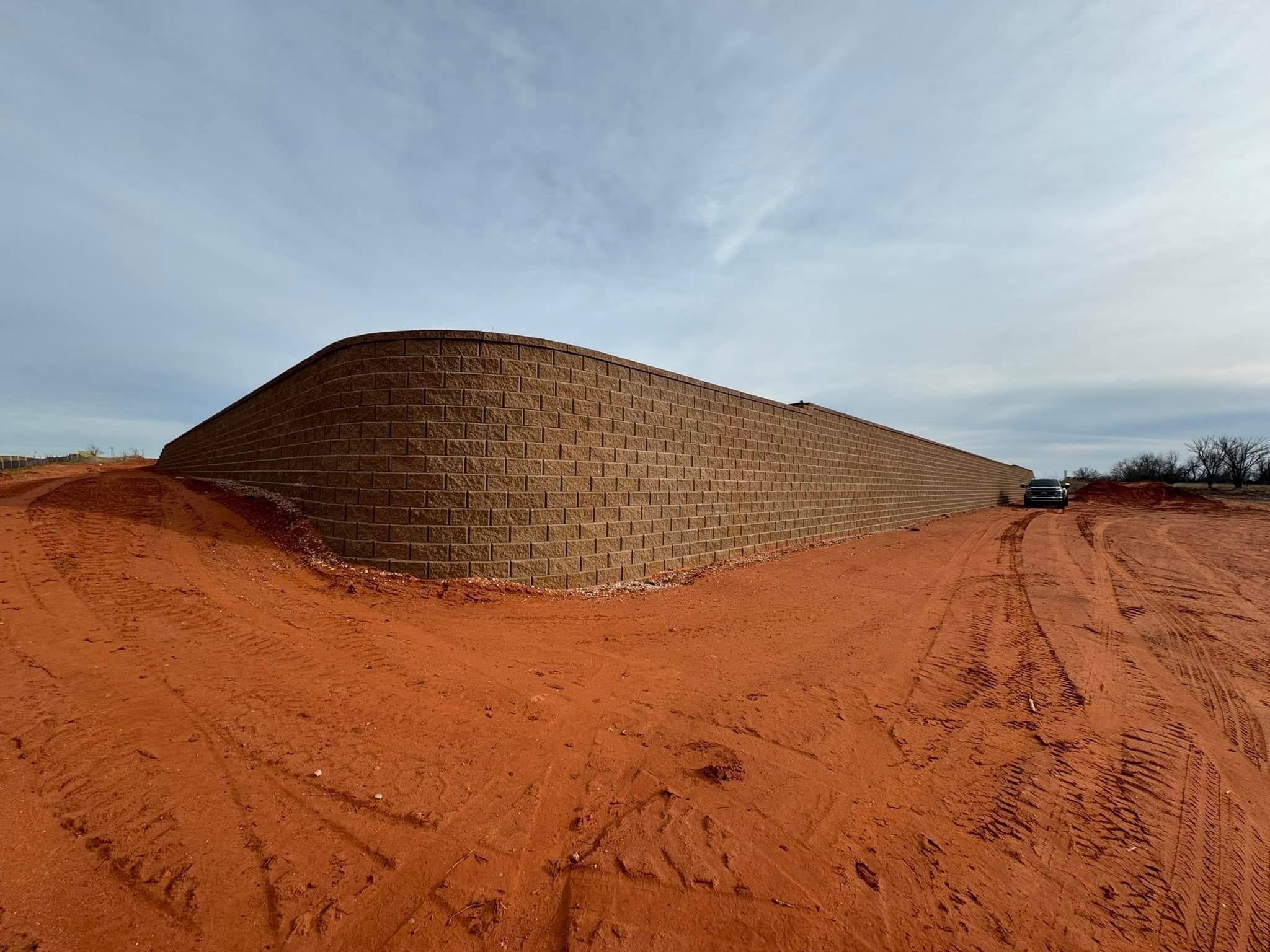 Large block retaining wall built on red Oklahoma dirt for Snow Enterprises